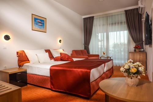 a hotel room with a large bed and a table at Hotel Makpetrol Struga in Struga