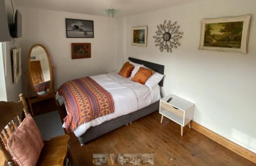 a bedroom with a bed and a mirror and a table at Room Stay 4 in Corran Cross Roads