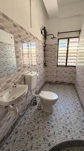 a bathroom with a toilet and a sink at the velvet nest in Watamu