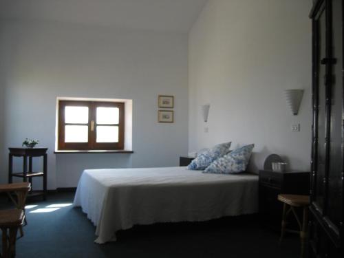 B&B Monvicino في Oviglio: غرفة نوم بيضاء بها سرير ونافذة