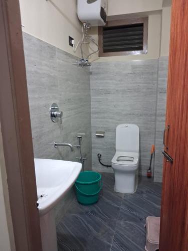 a bathroom with a white sink and a toilet at Demazong Homestay in Ravangla