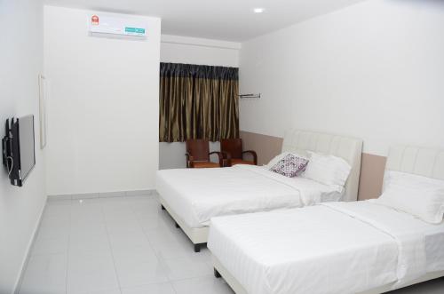une chambre d'hôtel avec deux lits et une fenêtre dans l'établissement Tanjung Homestay, à Ipoh