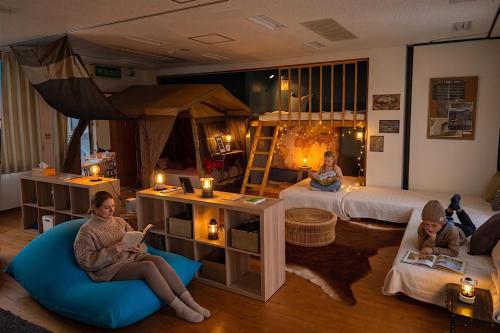 a group of people sitting in a room with a bed at アリビオ伊豆 in Ito