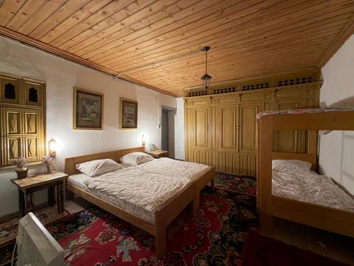 a bedroom with two beds and a wooden ceiling at National monument Mehmedbasica Kuca in Stolac
