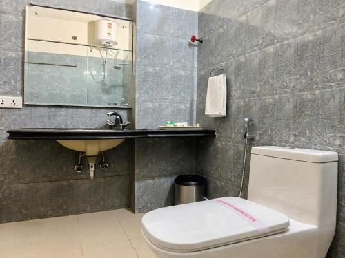 a bathroom with a white toilet and a sink at Hotel Roselle Heights in Jaipur