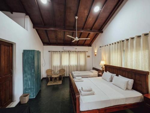 a bedroom with two beds and a ceiling at Galpothuyaya Eco Lodge Kandalama in Dambulla