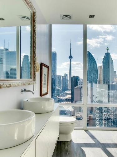 a bathroom with two sinks and a large window at Luxurious Panoramic Skyline Penthouse 2Bedrooms Suites CN Toronto Downtown in Toronto