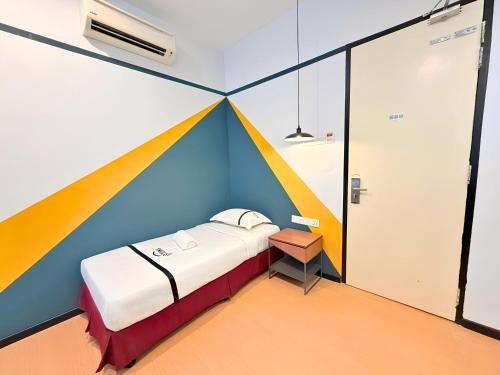 a room with a bed with a colorful wall at Seeds Hotel Kuala Selangor in Kuala Selangor