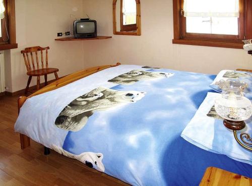 uma cama com um cobertor azul com um cão em Bait da Giusy em Livigno