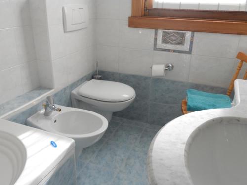 uma casa de banho com um WC branco e um lavatório. em Bait da Giusy em Livigno
