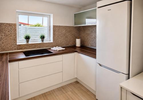 a kitchen with white cabinets and a window at Suite Coco in Maspalomas