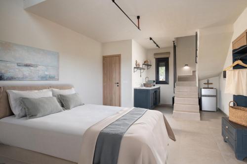 a bedroom with a large white bed and a staircase at Enos Retreat Villas in Agios Nikolaos