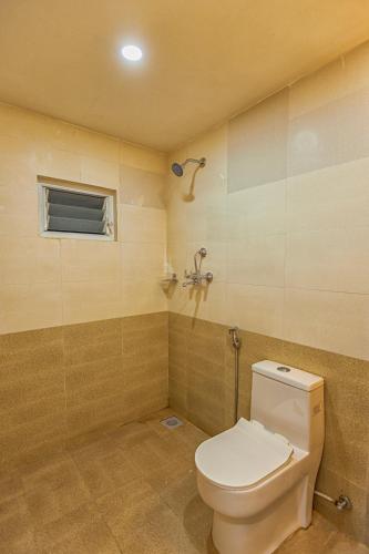 a bathroom with a white toilet and a window at Shikali Resort in Pātan