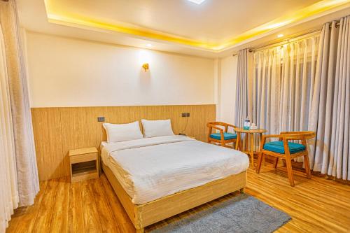a bedroom with a bed and a table and chairs at Shikali Resort in Pātan