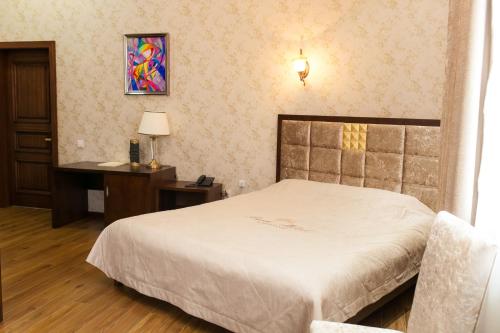 a bedroom with a bed and a desk and a bed sidx sidx sidx at Park Hotel in Karagandy