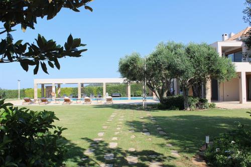 a villa with a swimming pool and a yard at Villa Lefka in Kastrosikia