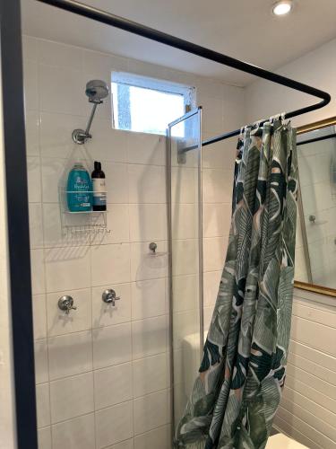 a shower with a shower curtain in a bathroom at Manly Beach Studio in Sydney