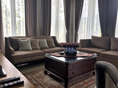 a living room with two couches and a coffee table at Avilla Puncak in Puncak