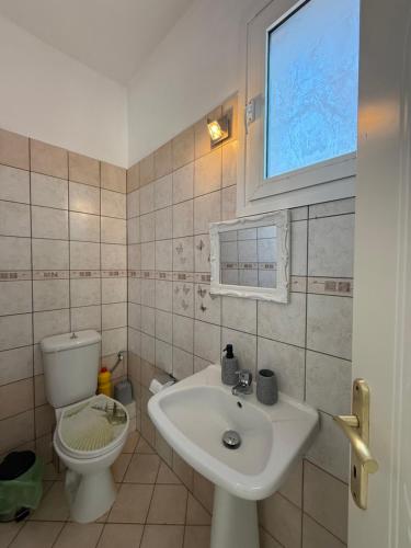 a bathroom with a sink and a toilet at Crystal seaview home in Iraklitsa