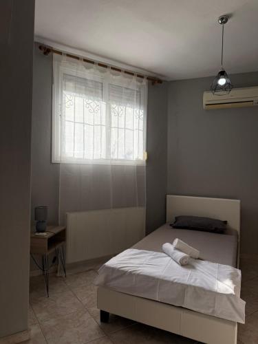 a bedroom with a white bed with a window at Crystal seaview home in Iraklitsa