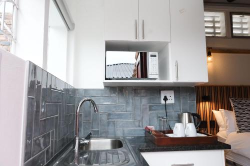 a kitchen with a sink and a microwave at Asali Lodge in East London