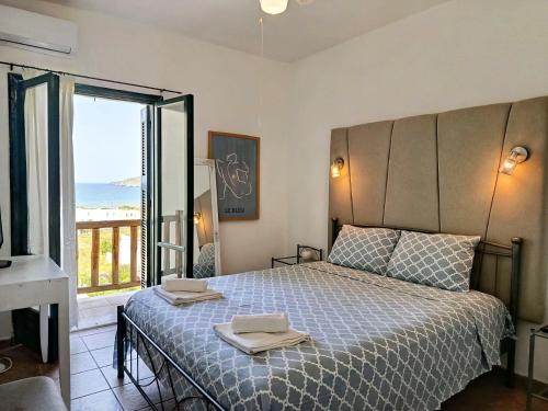 a bedroom with a bed with two towels on it at Cyclades Serenity Beach House in Kipri