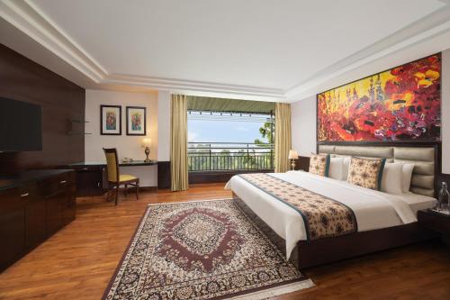 a bedroom with a large bed with a large painting on the wall at Fortune Park Moksha, Mcleodganj - Member ITC Hotels' Group in McLeod Ganj