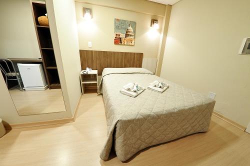a bedroom with a bed with two towels on it at Klein Ville Dois Irmãos in Dois Irmãos