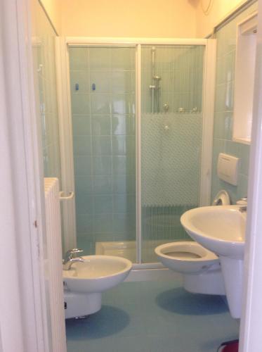 a bathroom with two sinks and a shower and a toilet at Alba Appartamenti in Sottomarina