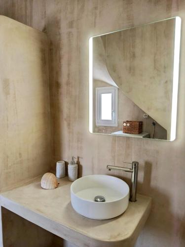 a bathroom with a white sink and a mirror at Cyclades Serenity Beach House in Kipri