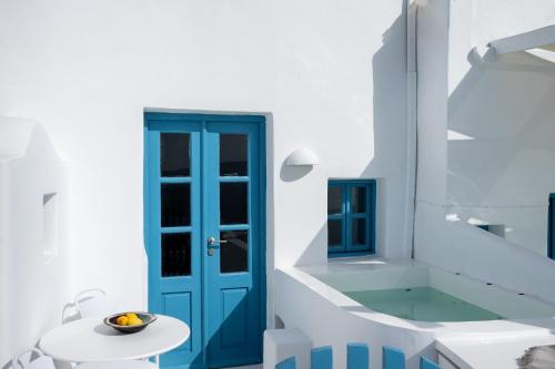 a bathroom with a blue door and a tub at Anemos Caldera Oia in Oia