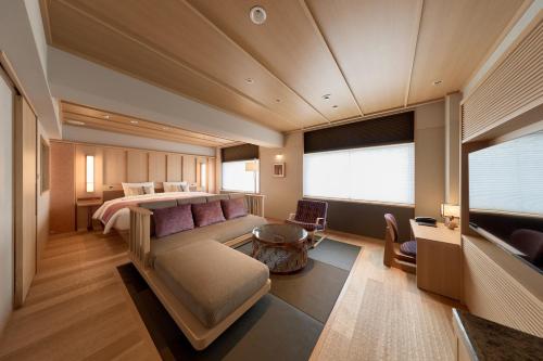 a bedroom with a bed and a couch and a table at Kyoto Century Hotel in Kyoto