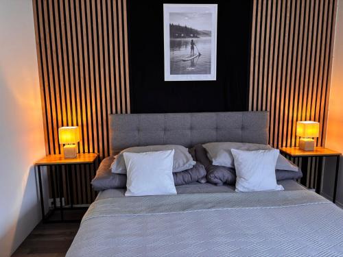 a bedroom with a bed with two lamps on both sides at rishko resort - Lake View - free Parking - 24hr Self chceck-in - Serviced Apartment Premium by Hotelstars Union in Holčíkovce