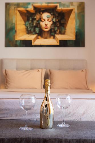 a bottle of champagne and two wine glasses on a table at Bill Apartments in Patra