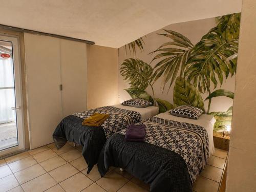 two beds in a room with a plant on the wall at le Moulin des Moines in Châtenois