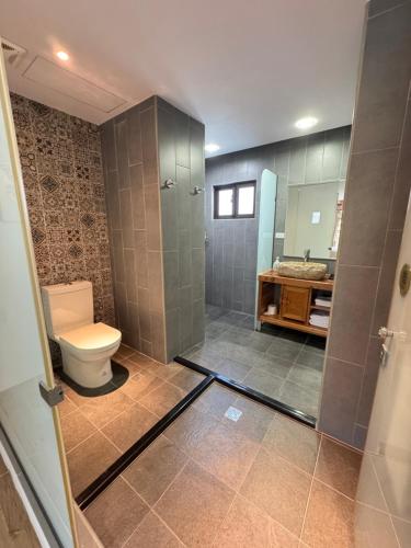 a bathroom with a toilet and a shower and a sink at Wanzai B&B in Xiaoliuqiu