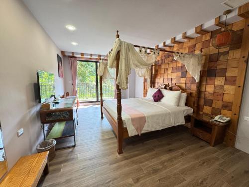 a bedroom with a canopy bed and a balcony at Wanzai B&B in Xiaoliuqiu