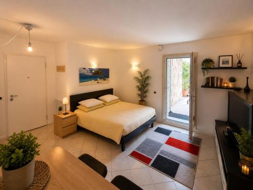 a bedroom with a bed and a table and a television at Il rifugio in Trento