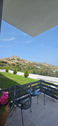 a patio with two chairs and a table on a balcony at Alora House 2 in Kefalos