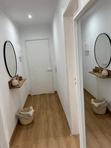 a hallway with two mirrors and a white door at Casa Borges in Quelfes