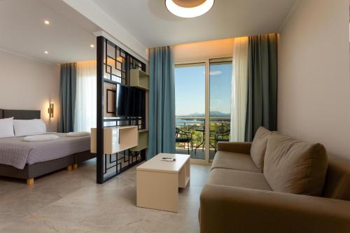 a living room with a couch and a bed at Corfelia Seaview Suites in Ipsos