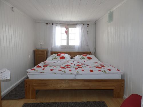 Bett in einem kleinen Zimmer mit Fenster in der Unterkunft Ferienwohnung Nina in Bildstein