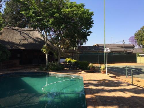 a swimming pool with a basketball hoop in a yard at Polokwane Place in Polokwane