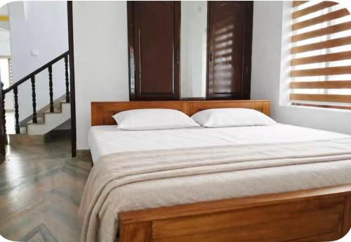 a bed with a wooden headboard in a bedroom at Kandass Homestay in Trichūr