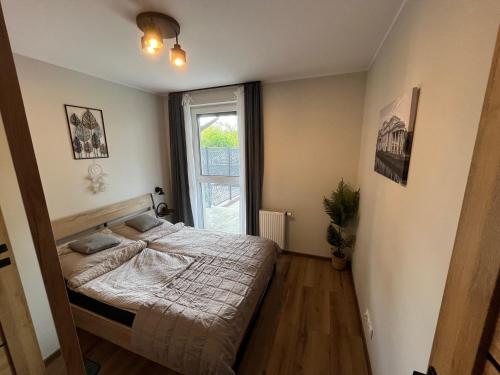 a small bedroom with a bed and a window at Apartament Calisia in Kalisz