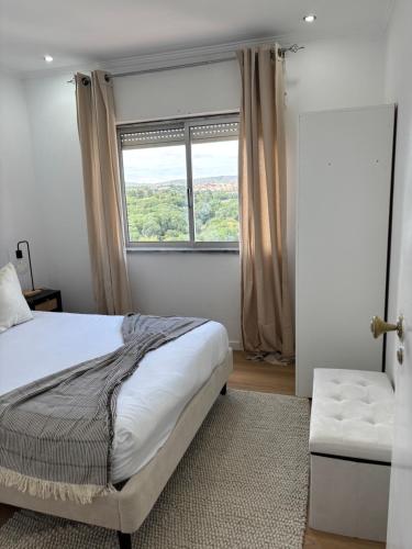 a bedroom with a bed and a window and a couch at Casa Borges in Quelfes