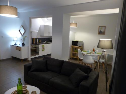 un salon avec un canapé et une table dans l'établissement Appartement Plein Centre Avignon, à Avignon