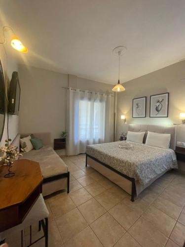 a bedroom with two beds and a table at ΑΡΓΩ in Kala Nera