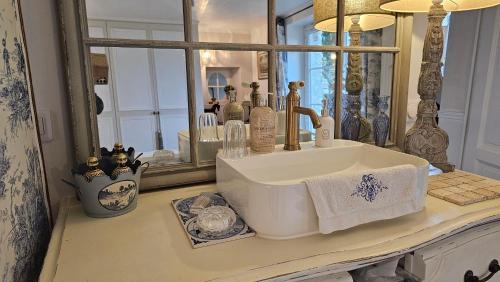a bathroom sink in front of a mirror at L'Orée d'Ermenonville in Borest
