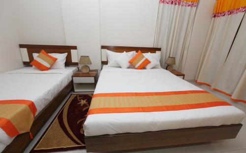two beds in a room with two at NAAS Serviced Apartments in Dhaka